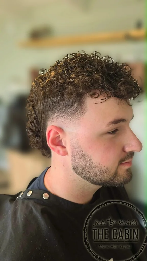 Profile view of curly perm with skin fade